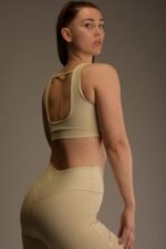 Naisten beige urheilutoppi leveillä olkaimilla ja avoimella selkäleikkauksella