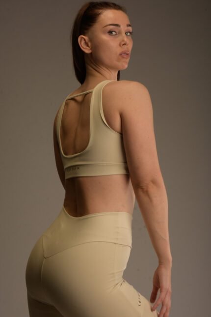 Naisten beige urheilutoppi leveillä olkaimilla ja avoimella selkäleikkauksella