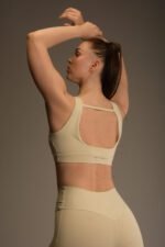 Naisten beige urheilutoppi leveillä olkaimilla ja avoimella selkäleikkauksella