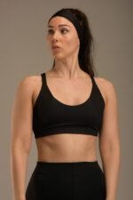 Naisten musta urheilutoppi ohuilla olkaimilla ja ribbikankaisilla yksityiskohdilla