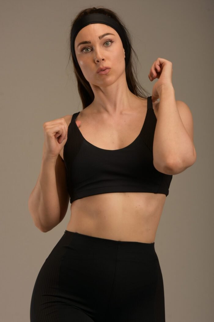 Women's black sports top with thin straps and ribbon details